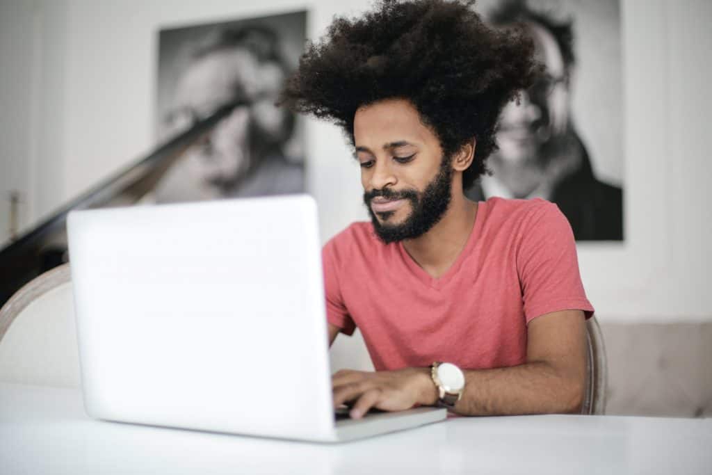 man in red crew neck t-shirt using laptop