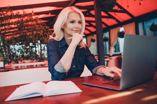 blonde woman looking at computer