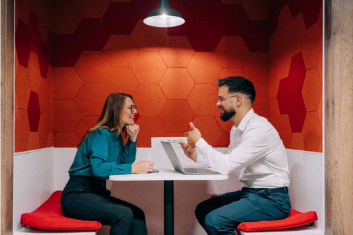Man and woman setting at a table in a restaurant talking business.